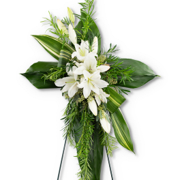 Tall cross-shaped arrangement of white lilies and lush green leaves on an easel stand