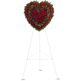Heart-shaped standing arrangement of red roses and red and green carnations on a white easel
