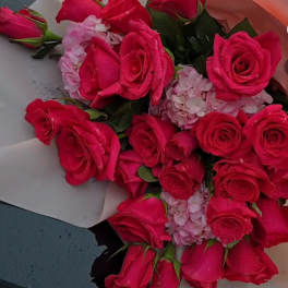 Bouquet of hot pink roses and pale pink hydrangea wrapped in paper