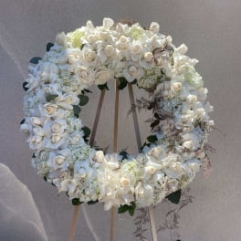 Large white floral wreath on a wooden easel