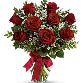 Bouquet of red roses with white filler flowers in a glass vase