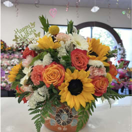Mixed bouquet with sunflowers, roses, and carnations in a decorative pot