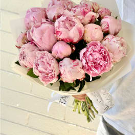 Bouquet of pink peonies wrapped in white paper