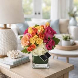 Colorful bouquet of roses and tulips in a glass vase