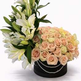 White lilies and peach roses in a black round box with pearl trim