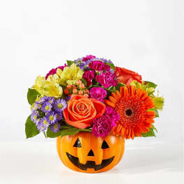 Colorful flower arrangement in a jack-o'-lantern pumpkin container