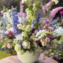 Mixed bouquet of pastel flowers in a white vase