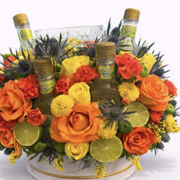 Orange and yellow floral arrangement with three mini liquor bottles and lime slices