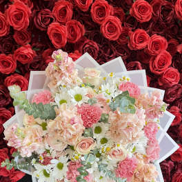 Bouquet of pink and white flowers wrapped in translucent paper