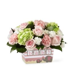 Pink and white floral arrangement in a baby-themed box