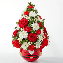 Red and white floral arrangement in a Santa-shaped container