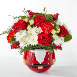 Red roses and white daisies in a Santa-shaped vase