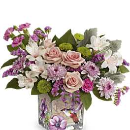 Pink and white flower arrangement in a square glass vase