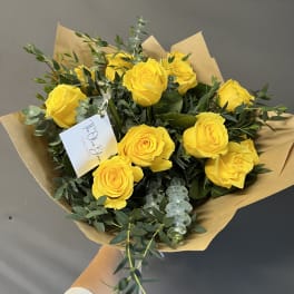 Bouquet of yellow roses wrapped in brown paper