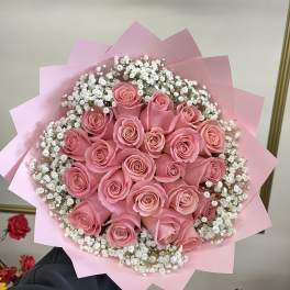 Bouquet of pink roses with white baby's breath in pink wrapping