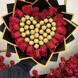 Heart-shaped bouquet of red roses and gold-wrapped chocolates