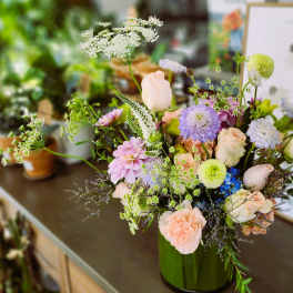 Pastel mixed flower arrangement in a green vase