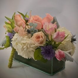 Pastel flower arrangement in a rectangular glass vase