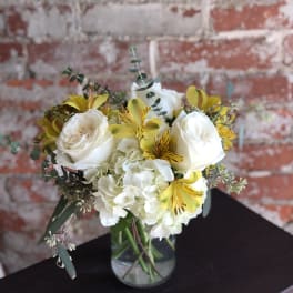White roses and yellow alstroemeria in a glass vase