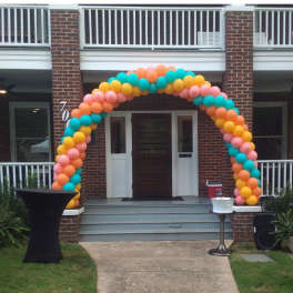 Colorful balloon arch framing a house entrance
