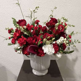 Red and white floral arrangement in a white vase