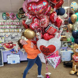 Large cluster of heart-shaped Valentine balloons in red, white, pink, and gold