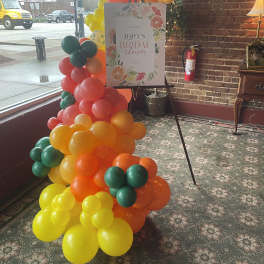 Colorful balloon arch beside a bridal shower sign