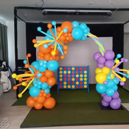 Colorful balloon arch around a Connect Four game board