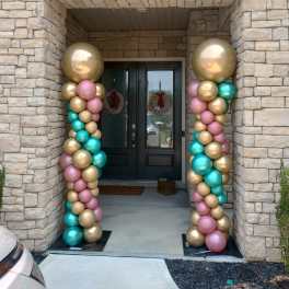 Pastel and metallic balloon columns framing a front door