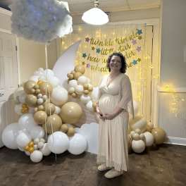 Gold and white balloon display with a cloud and moon backdrop