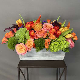Colorful mixed flower arrangement in a rectangular wooden box