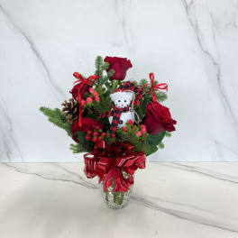 Christmas bouquet of red roses with a snowman ornament in a glass vase