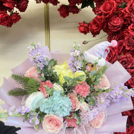 Pastel bouquet with roses, hydrangea, and a small plush toy in a hat