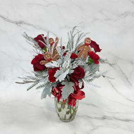 Red roses and carnations in a glass vase with gingerbread ornaments