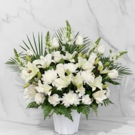 White lilies and chrysanthemums arranged in a white vase