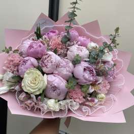Pink bouquet of peonies and roses wrapped in pink paper