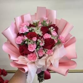 Pink and red rose bouquet with carnations wrapped in pink paper