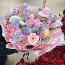 Pastel bouquet with pink roses, gerbera daisies, and a gingerbread decoration