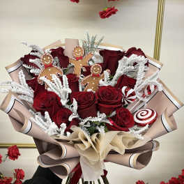 Bouquet of red roses with gingerbread decorations and candy accents