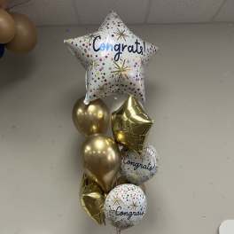 Cluster of gold and printed congratulatory balloons with a star balloon