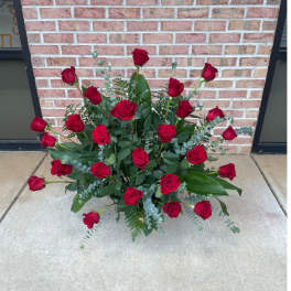Arrangement of red roses with greenery on the ground