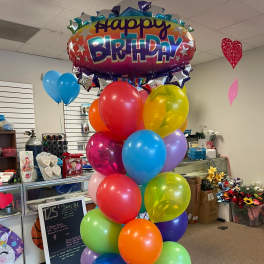 A large birthday balloon bouquet with a "Happy Birthday" foil balloon