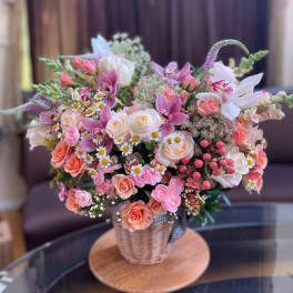 Pink and peach mixed bouquet in a woven basket