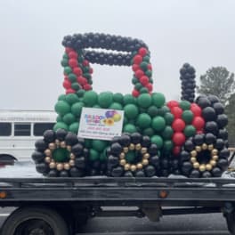 Balloon display shaped like a tractor on a flatbed truck