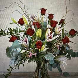 Red roses and lilies in a clear glass vase