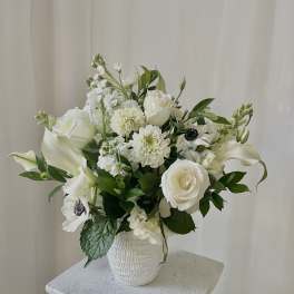 White floral arrangement in a textured white vase