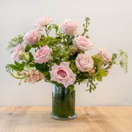 Pink roses arranged in a clear glass vase