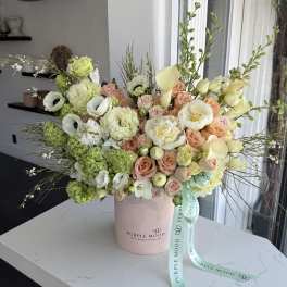 Large pastel bouquet in a pink hatbox with a ribbon