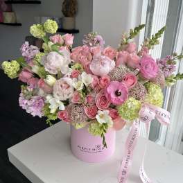 Pink and white mixed flower bouquet in a pink hatbox with ribbon
