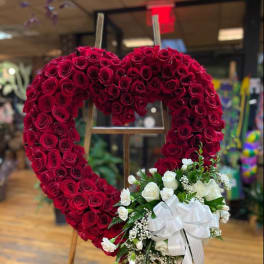 Heart-shaped red rose wreath with a white rose bouquet and ribbon